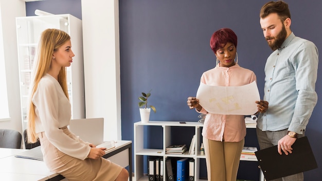 Vrouw die collega&#39;s bekijken die concept bespreken