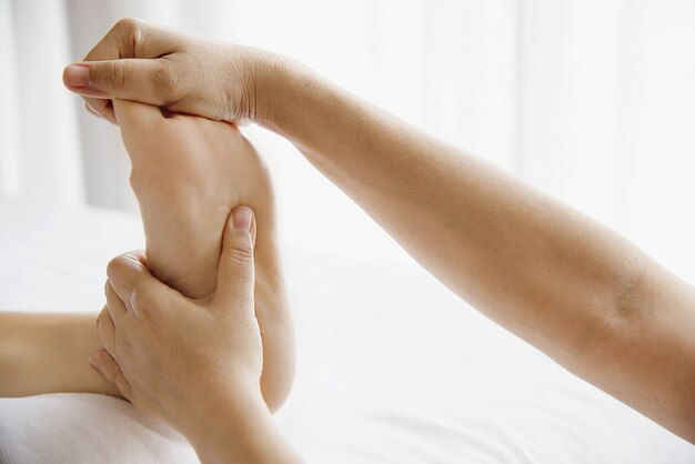 Vrouw die de dienst van de voetmassage van masseuse ontvangt dichtbij dichtbij en voet - ontspan in het concept van de de therapiedienst van de voetmassage