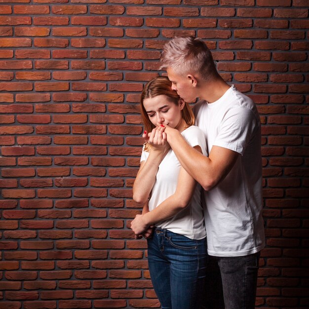 Vrouw die de hand van haar vriend met exemplaarruimte kust