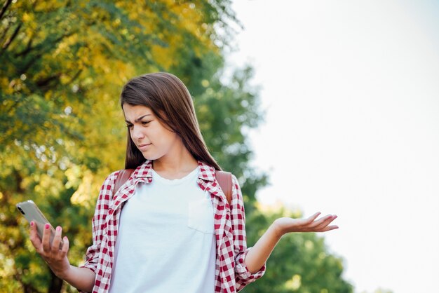 Vrouw die de verwarde telefoon bekijkt