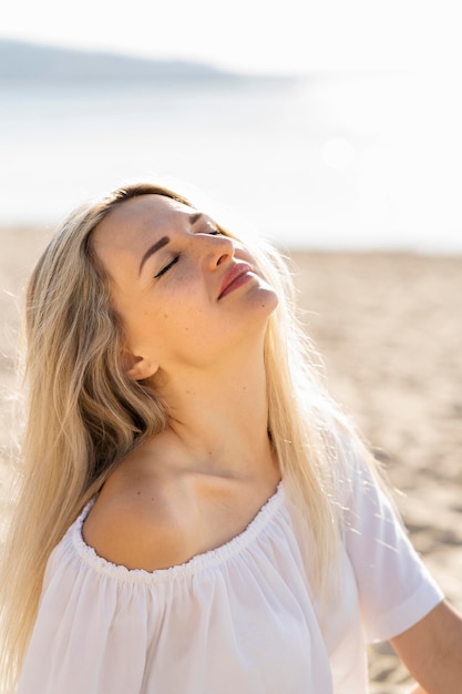 Vrouw die de zon doorweekt bij het strand