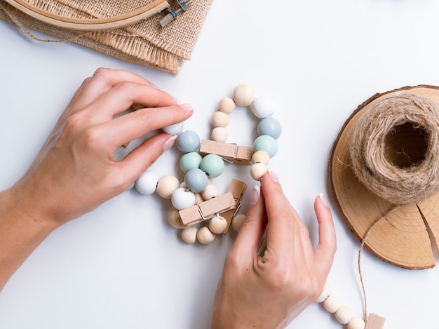 Vrouw die decoratie met houten parels maakt