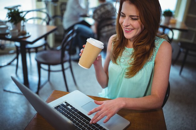 Vrouw die digitale tablet in cafe