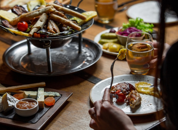 Vrouw die diner eet rond de lijst die met voedsel wordt geschonken