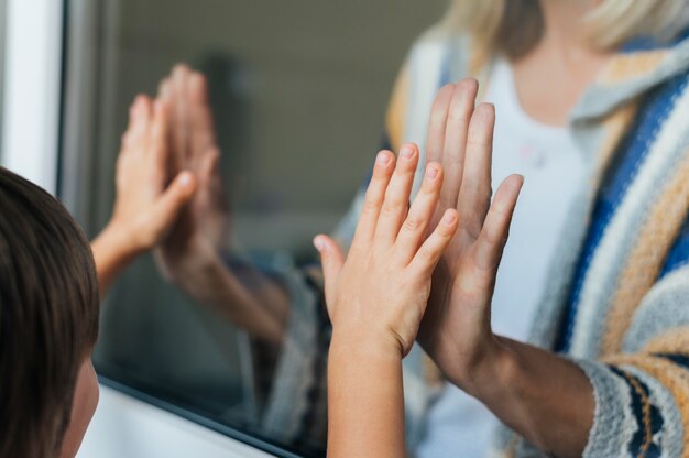 Vrouw die door het raam hallo zegt tegen neef