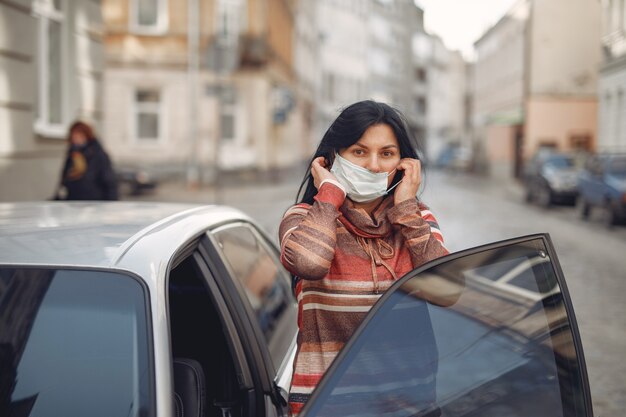Gratis foto vrouw die een beschermend masker draagt dat in in een auto komt