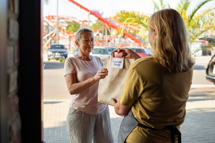 Gratis Foto vrouw die een bestelling geeft aan een klant bij een pick-up buiten de stoep