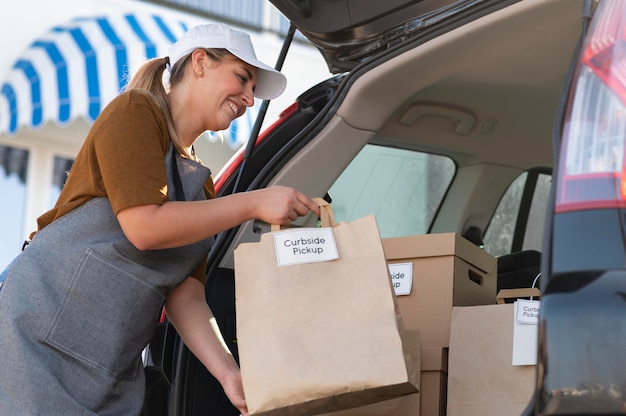 Vrouw die een bestelling geeft bij een pick-up langs de stoep