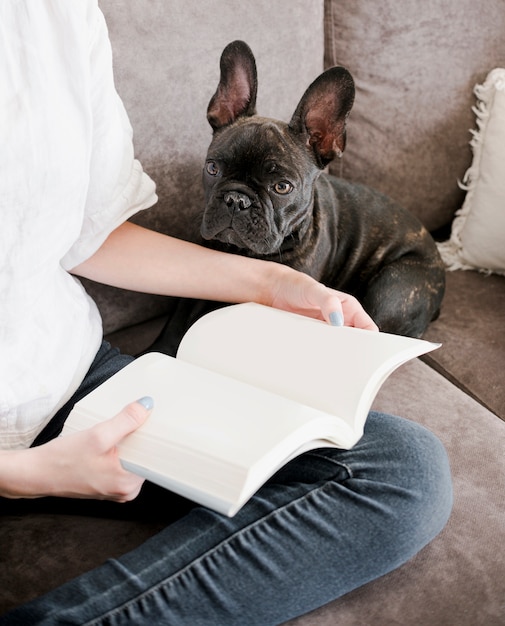 Vrouw die een boek met haar puppy leest