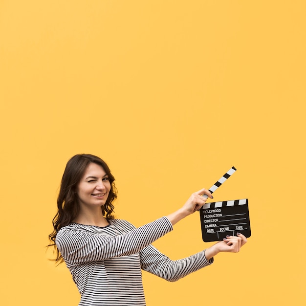 Vrouw die een clapperboard met exemplaarruimte houdt