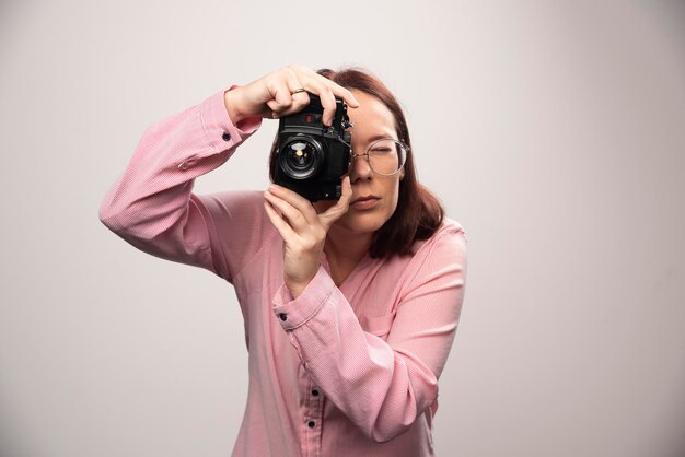 Vrouw die een foto maakt met camera op wit. Hoge kwaliteit foto