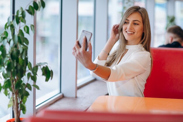 Vrouw die een foto met haar mobiele telefoon om zichzelf