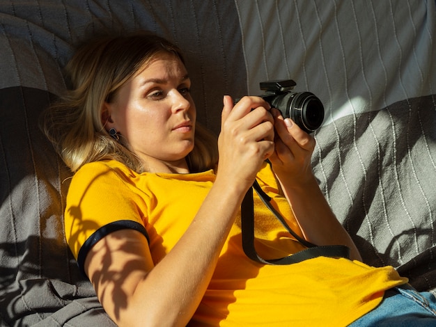 Gratis foto vrouw die een fotocamera in bed houdt