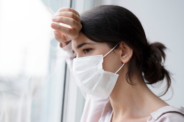 Vrouw die een gezichtsmasker draagt tijdens thuis