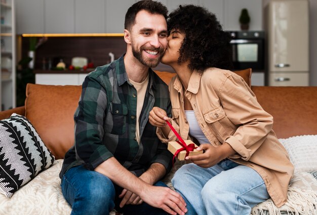 Vrouw die een gift houdt en een man kust