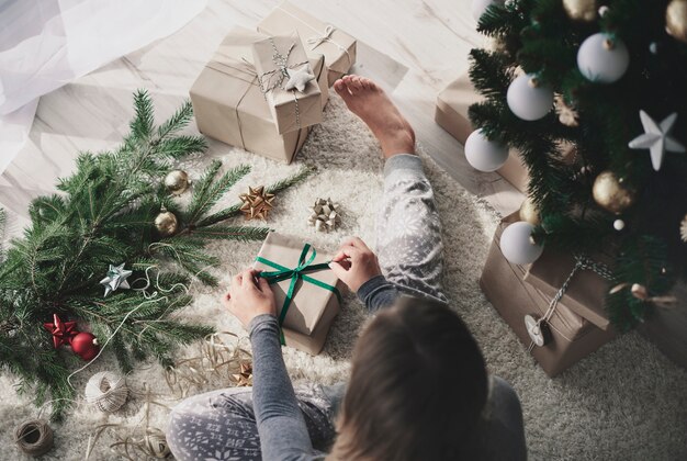 Vrouw die een gift op vloer voorbereidt