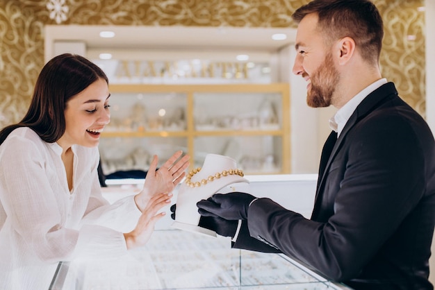 Vrouw die een ketting kiest bij juwelier