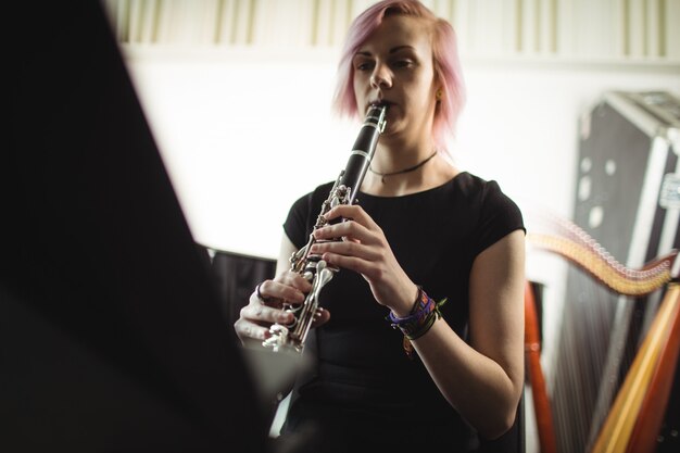 Vrouw die een klarinet in muziekschool speelt