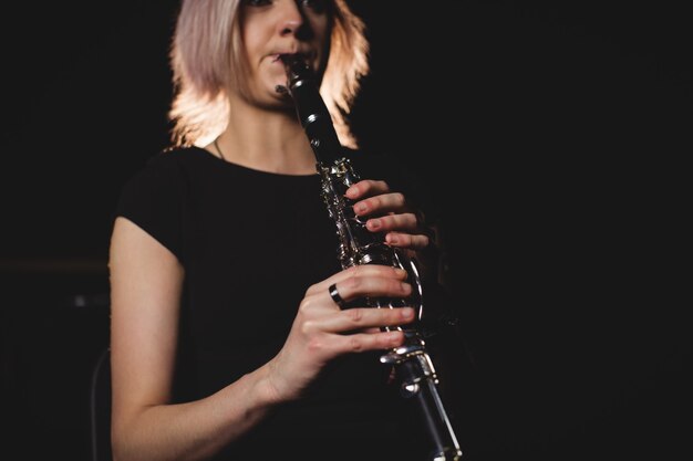 Vrouw die een klarinet in muziekschool speelt