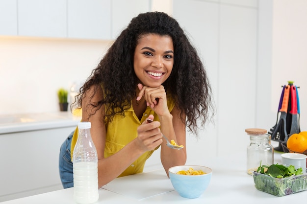 Vrouw die een kom granen met melk voorbereidt