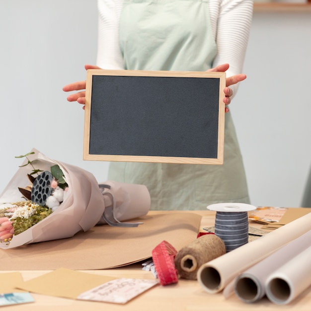 Gratis foto vrouw die een leeg exemplaar ruimtebord houdt