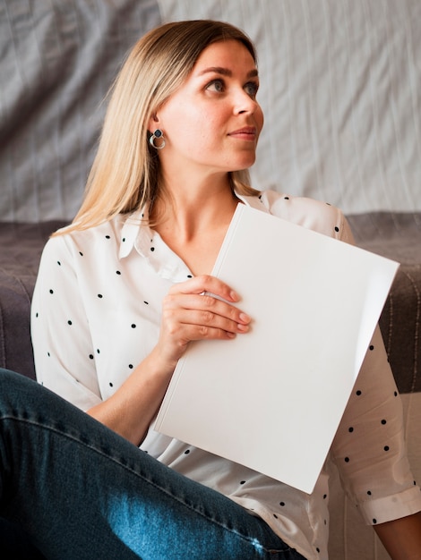 Vrouw die een modeltijdschrift houdt