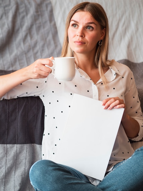 Vrouw die een modeltijdschrift houdt