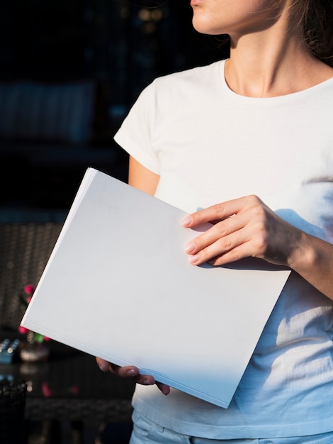 Gratis foto vrouw die een modeltijdschrift houdt