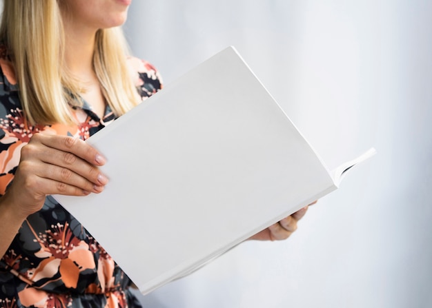 Vrouw die een modeltijdschrift houdt