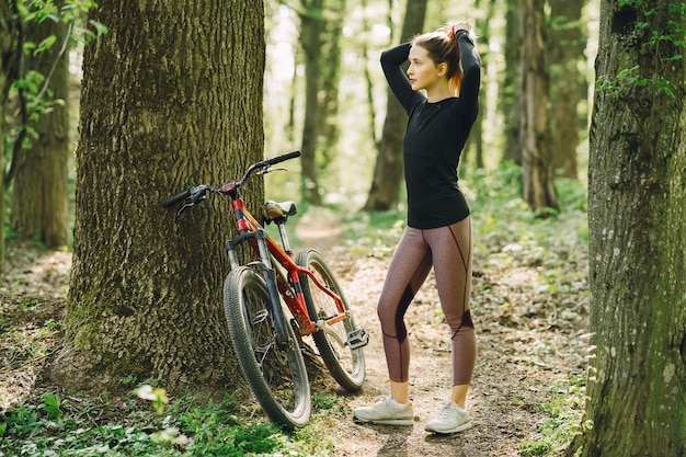 Vrouw die een mountainbike in het bos berijdt