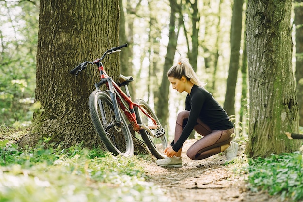 Vrouw die een mountainbike in het bos berijdt