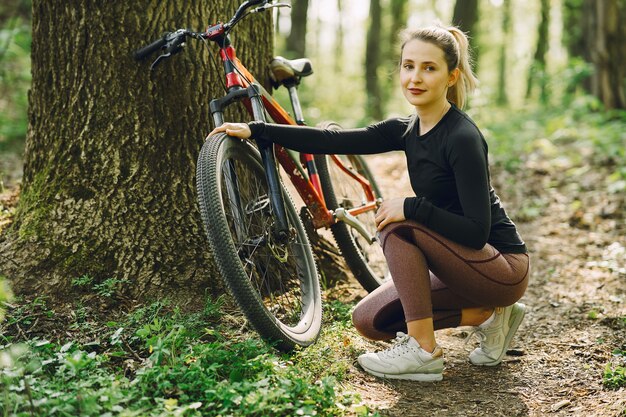 Vrouw die een mountainbike in het bos berijdt