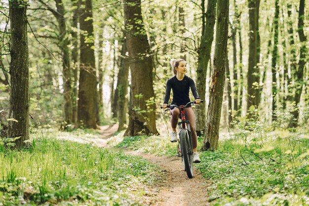 Vrouw die een mountainbike in het bos berijdt