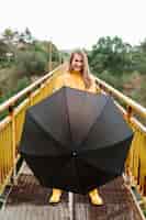 Gratis foto vrouw die een open zwarte paraplu tegenhoudt