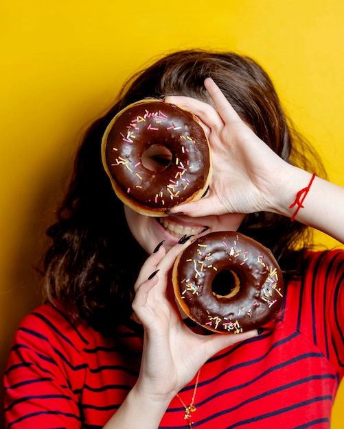 Vrouw die een paar donuts met chocolade houdt