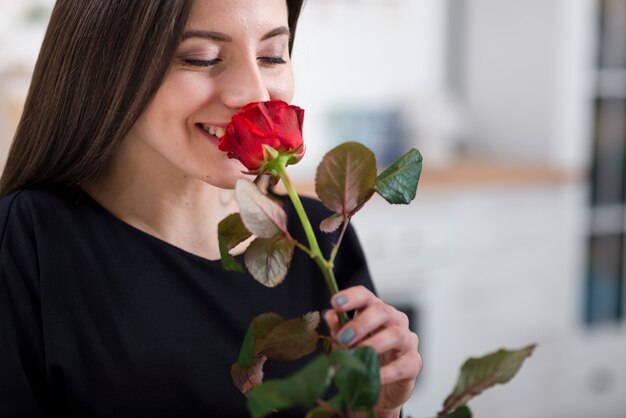 Vrouw die een roos van haar man ruikt
