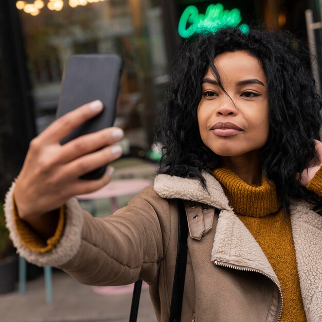Vrouw die een selfie met haar smartphone buiten neemt