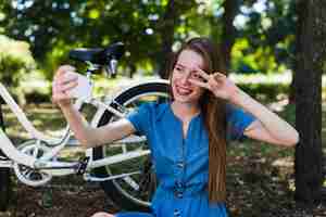 Gratis foto vrouw die een selfie naast haar fiets neemt