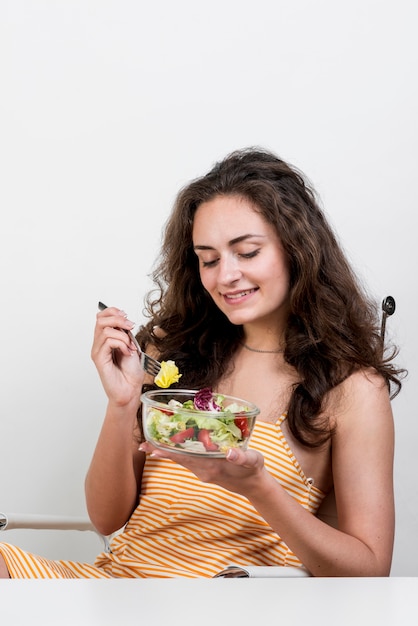 Gratis foto vrouw die een sla slaatje eet