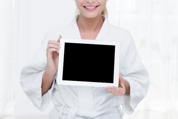 Vrouw die een tablet in een kuuroord gebruikt