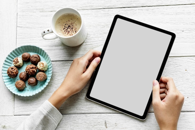 Vrouw die een tablet met een leeg scherm gebruikt, werkt vanuit huis