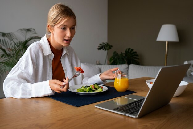 Vrouw die een videogesprek voert terwijl ze eet