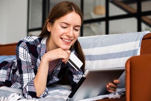 Vrouw die en een creditcard glimlacht houdt
