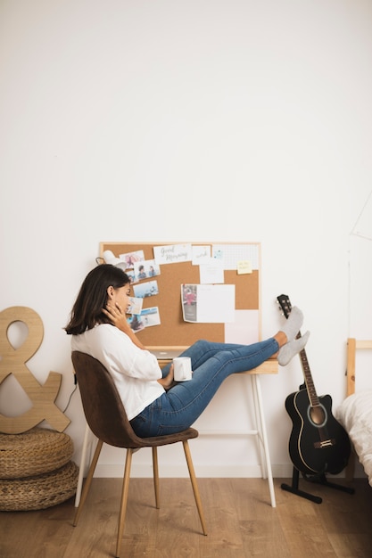 Gratis foto vrouw die en een koffiekop ontspant houdt