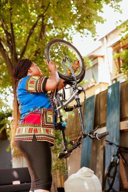 Vrouw die fietswiel in de tuin weer bevestigt