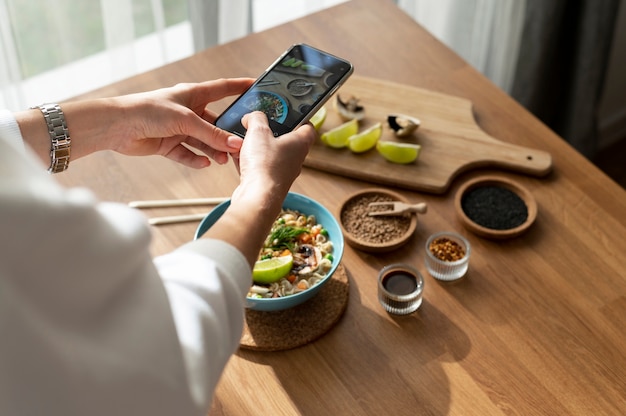 Vrouw die foto neemt van kom met ramen en gesneden citroen