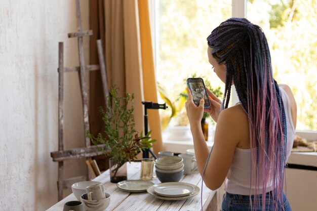 Vrouw die foto's maakt van keramisch keukengerei