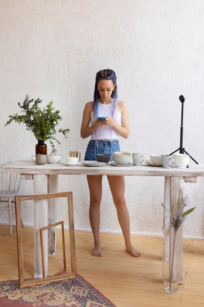 Gratis foto vrouw die foto's maakt voor haar bedrijf met keukengerei