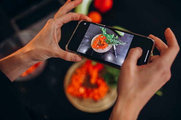 Vrouw die foto van een maaltijd op haar telefoon maakt