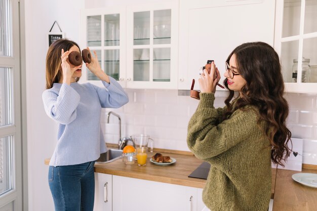 Vrouw die foto van vriend met donuts neemt